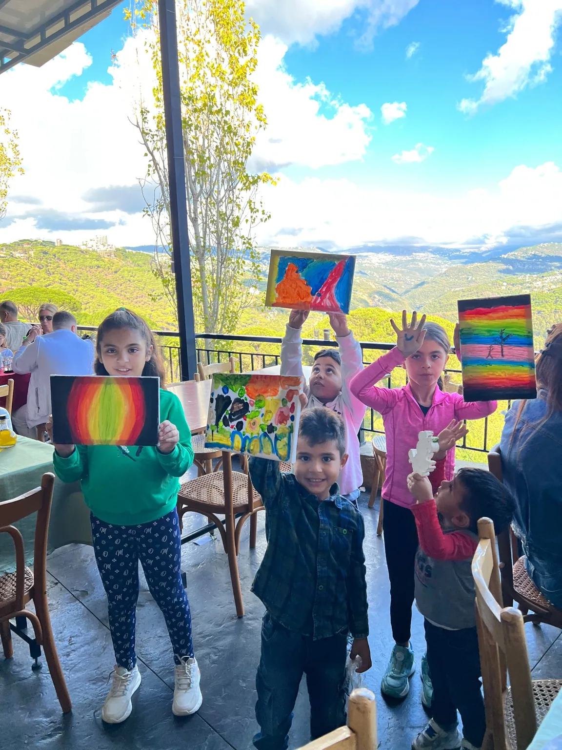 Children showing their paintings on the terrace